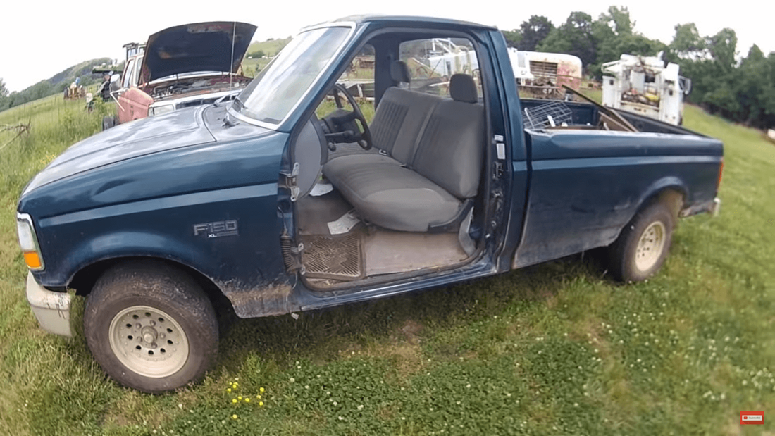 Old junk Ford F-150 pickup truck on farm property